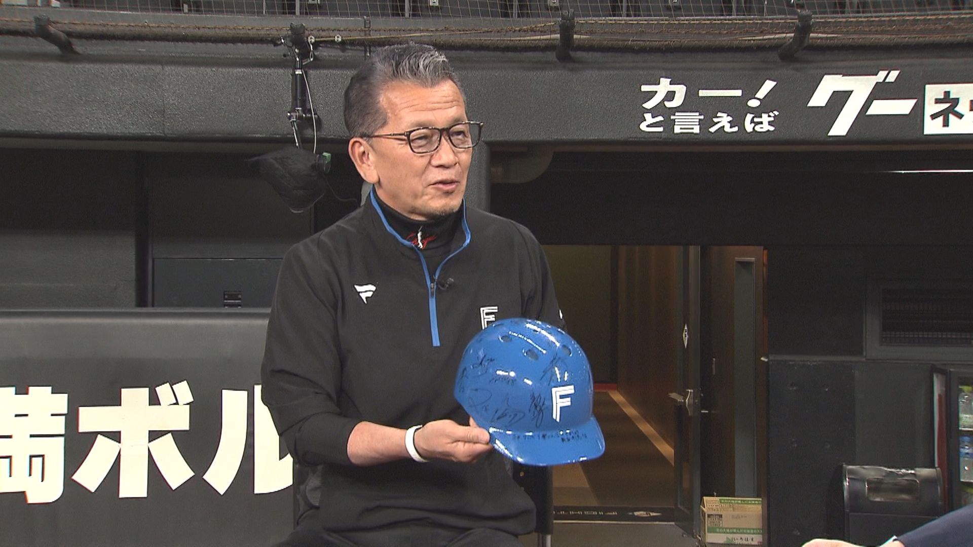 闘病中に新庄監督から贈られたヘルメットを持つ小村社長