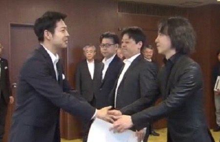 道庁着任時に鈴木知事と握手する山崎氏（2019年）