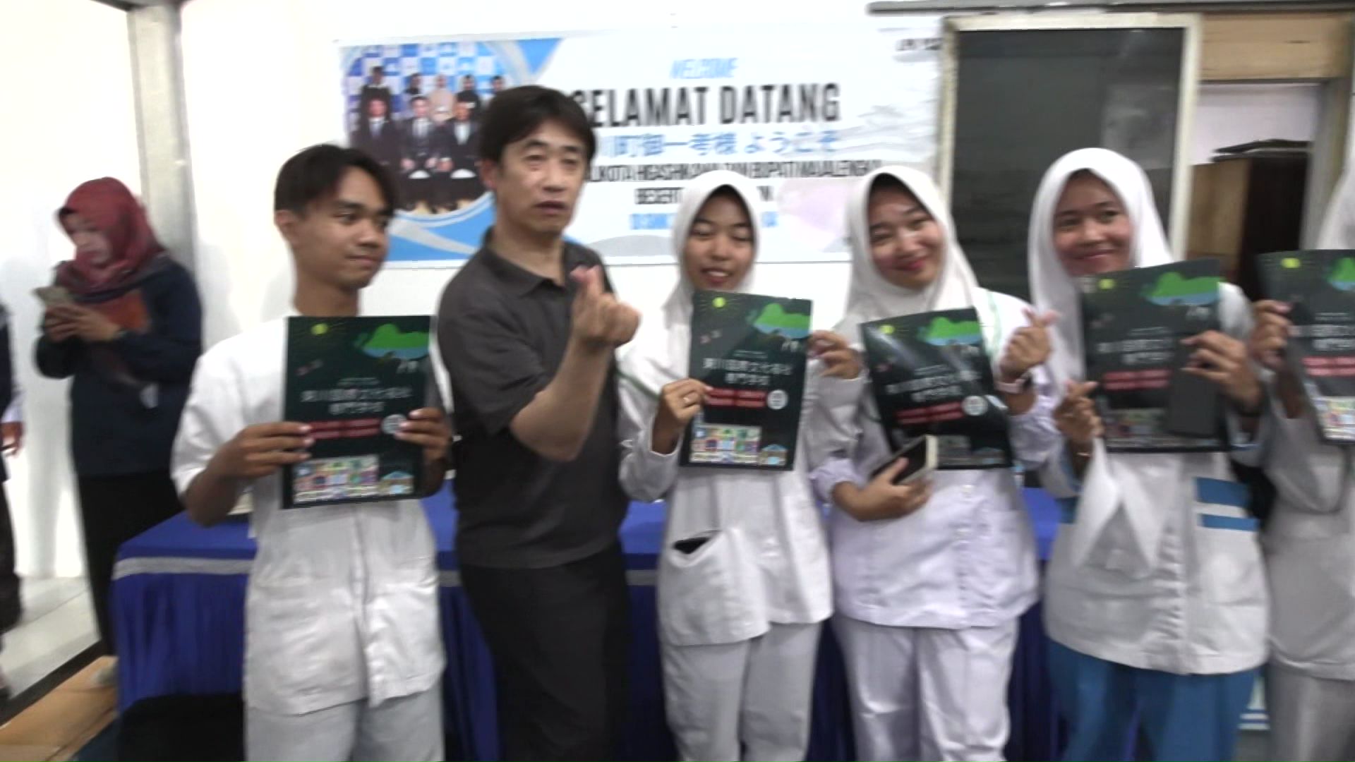 学生とポーズをとる富塚さん