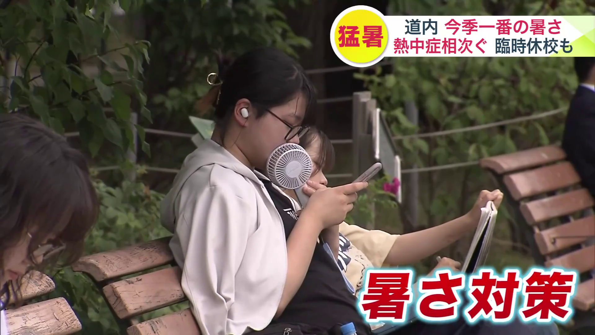 ハンディファンなどで暑さ対策をする人も