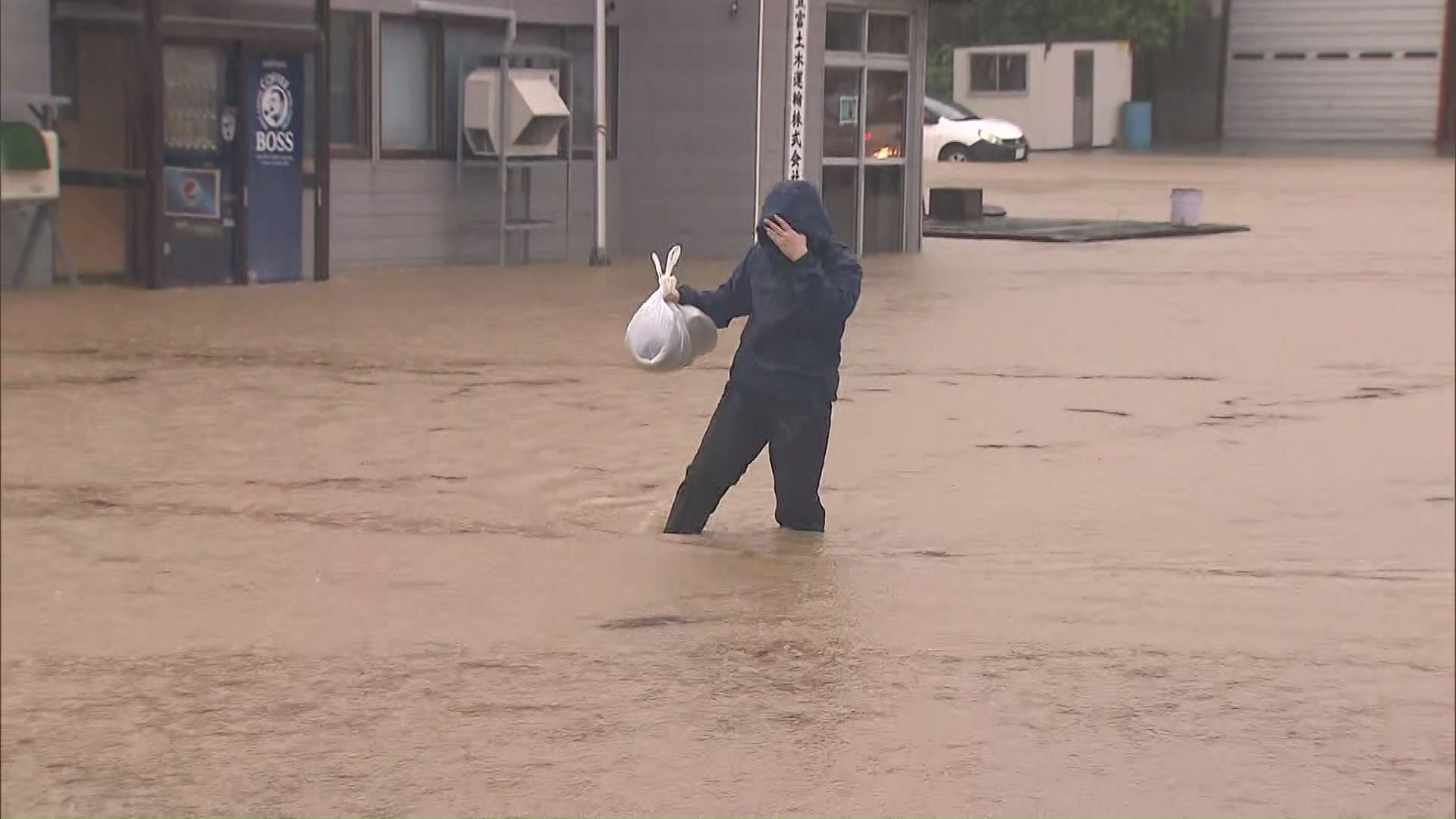 ひざ下まで浸かりながら歩く人