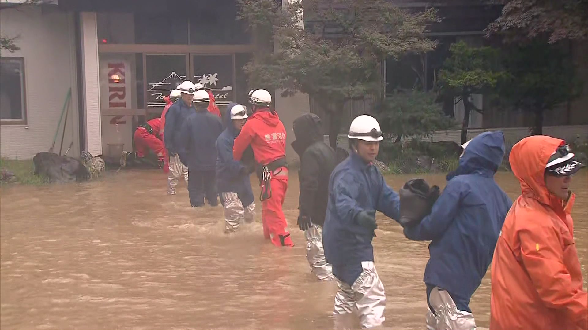 消防隊員らが土のうを運び浸水対策