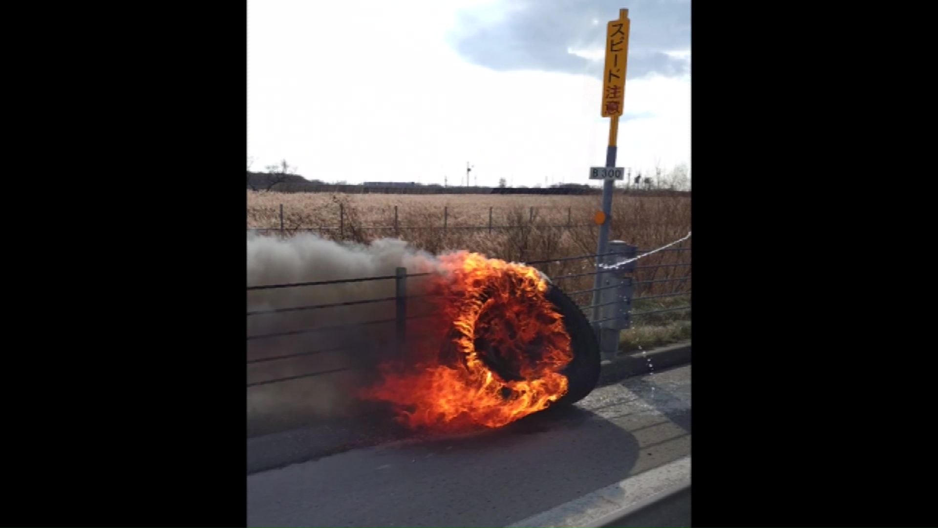 脱落したタイヤが道路脇で出火し延焼(撮影:視聴者)