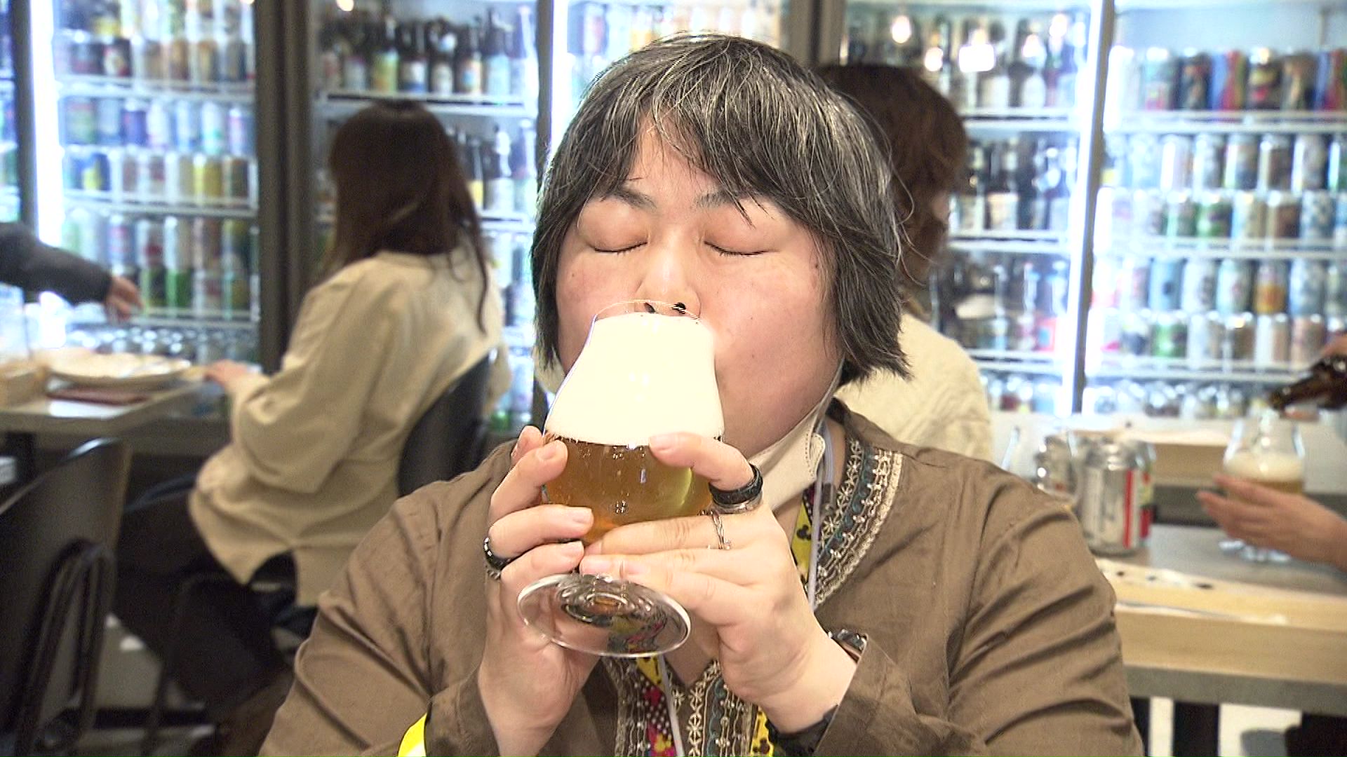 ビールをグラスに注ぎ楽しむ客