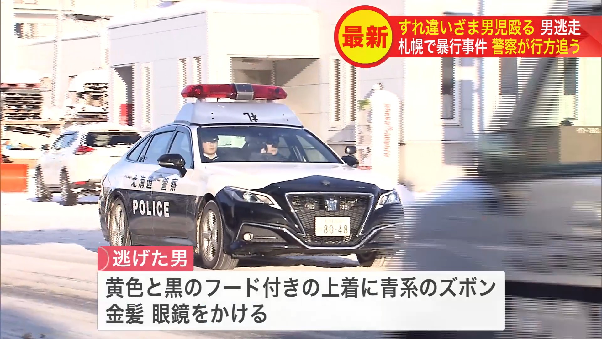 黄色と黒のフード付きの上着に青っぽいズボンをはき、金髪に眼鏡