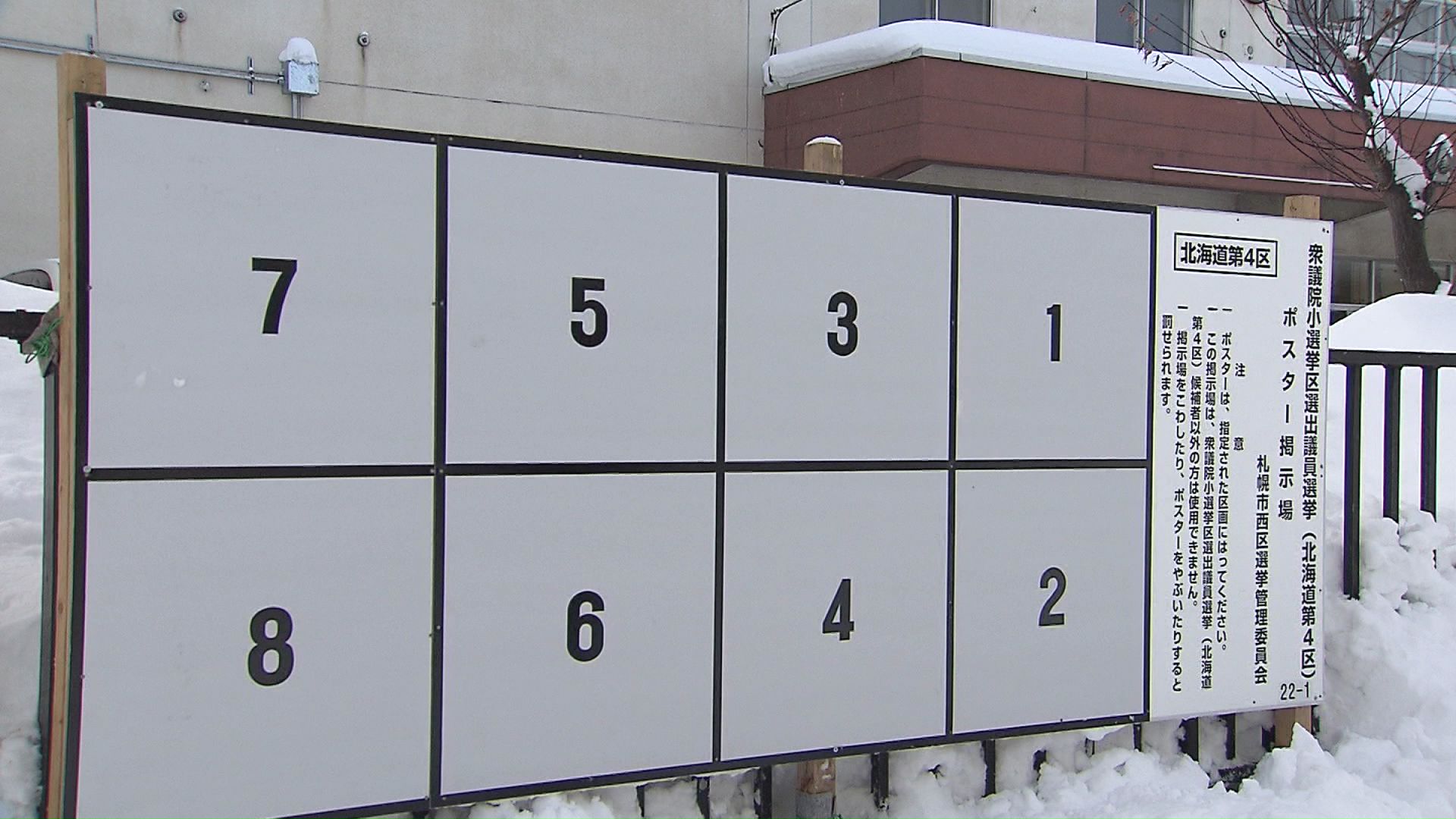 雪の中設置される選挙の掲示板