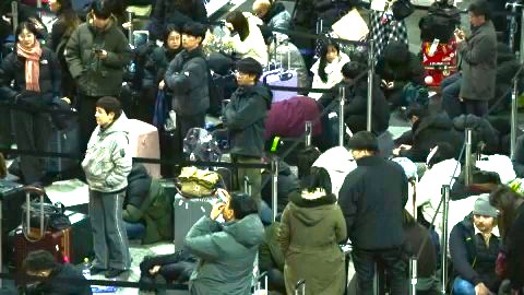 空港内で一夜を明かした人々