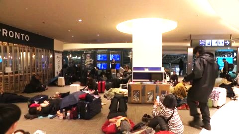 空港内で一夜を明かした人々