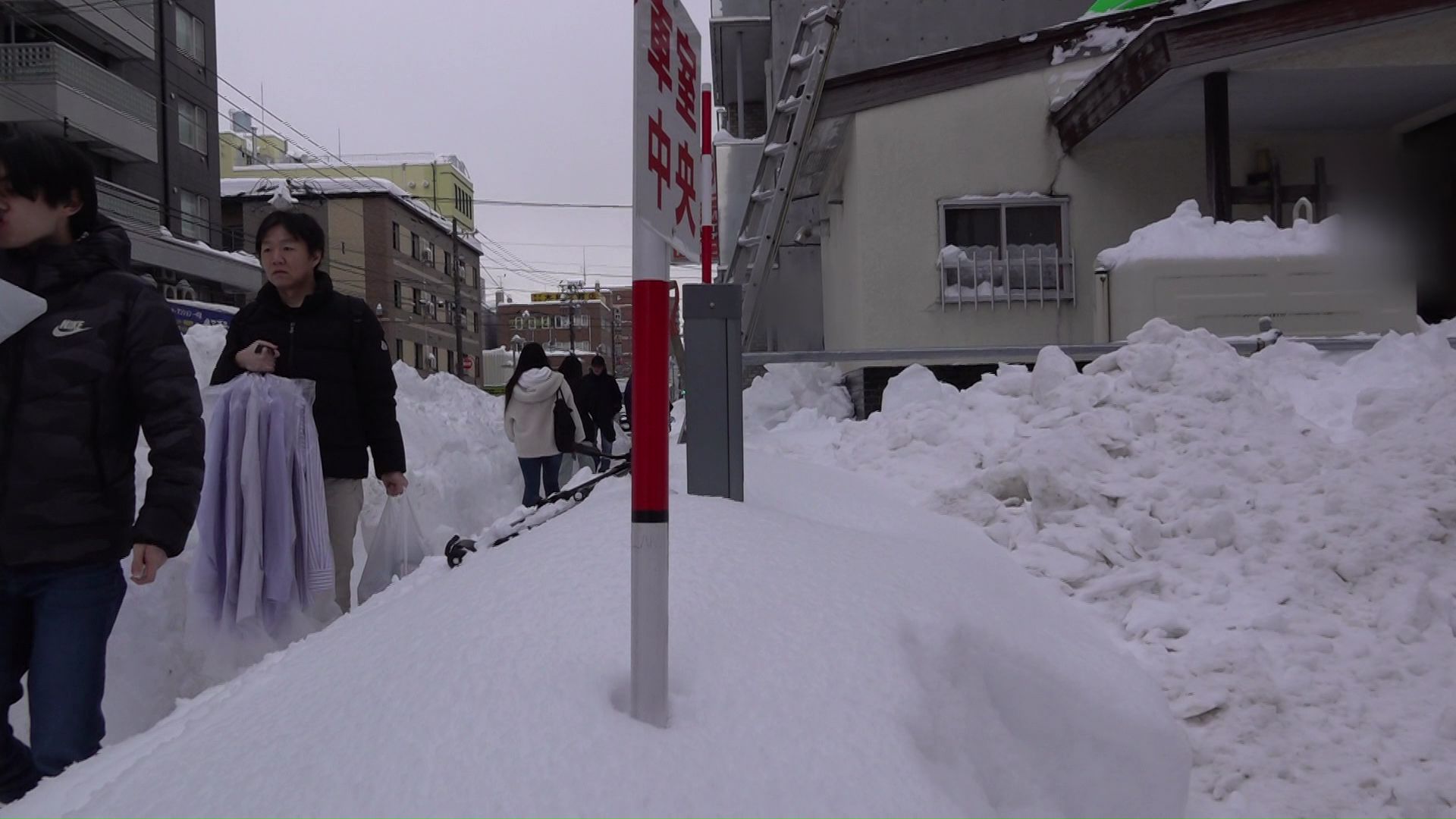 大雪で狭くなった歩道