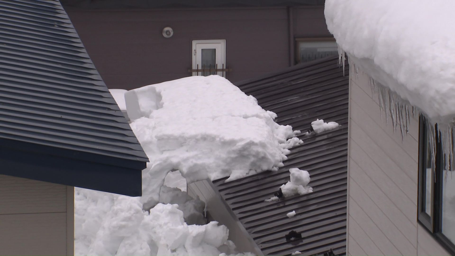 落雪のあった建物の屋根には大きな雪の塊が残っている