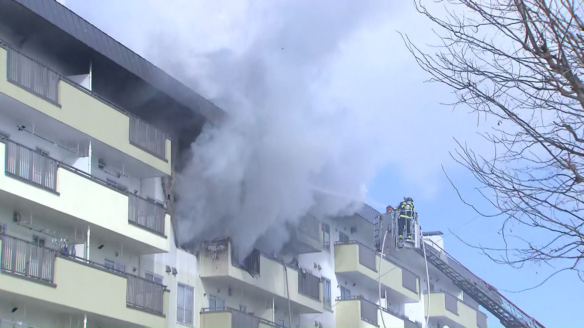 共同住宅の一室から勢いよく吹き出す煙