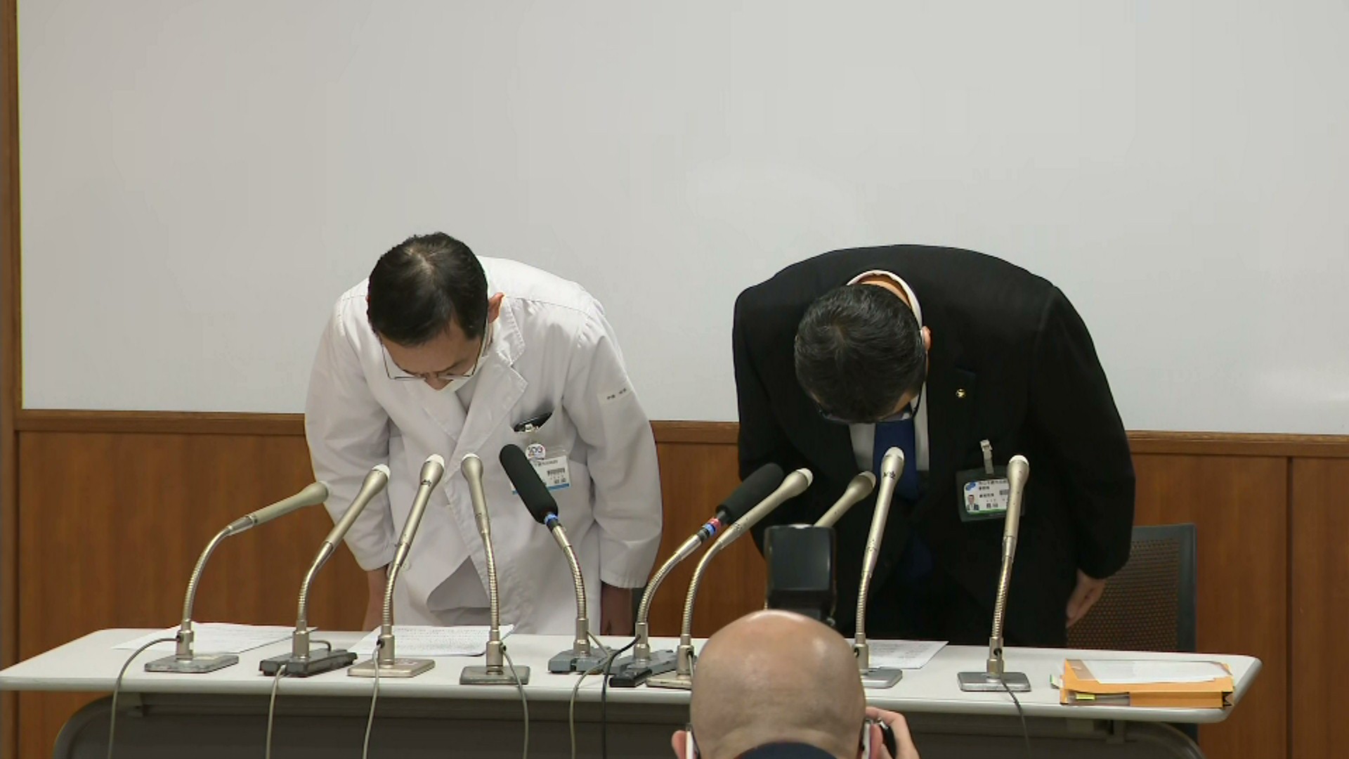 会見で陳謝する院長（左）と事務局長（右）