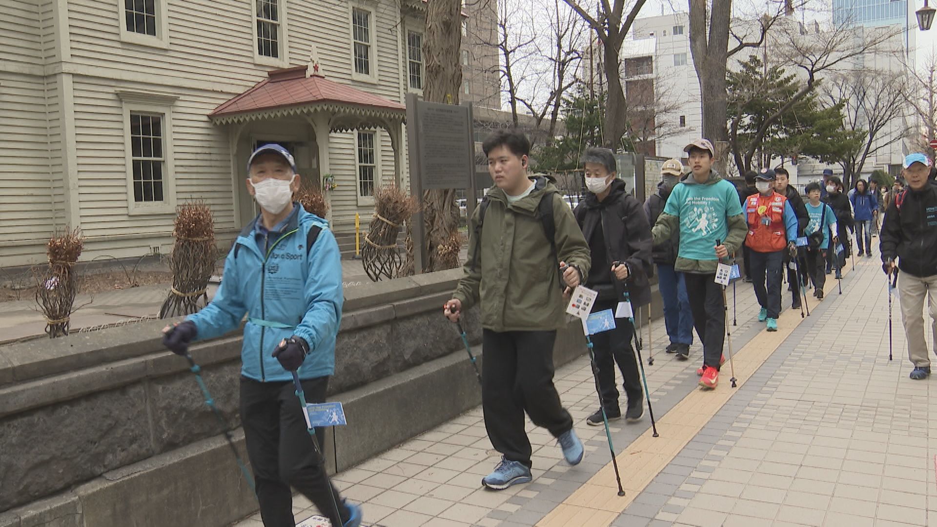 障がいへの理解を求め青の衣類などでウォーキング